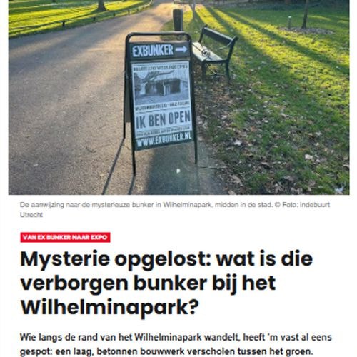 Reclamebord in het zonnige Wilhelminapark: 'EXBUNKER → IK BEN OPEN' en 'www.exbunker.nl'. Groen gras, bomen en pad.