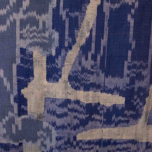 Een close-up van blauw-witte geweven stof met een abstract, onregelmatig patroon van lijnen en golven.