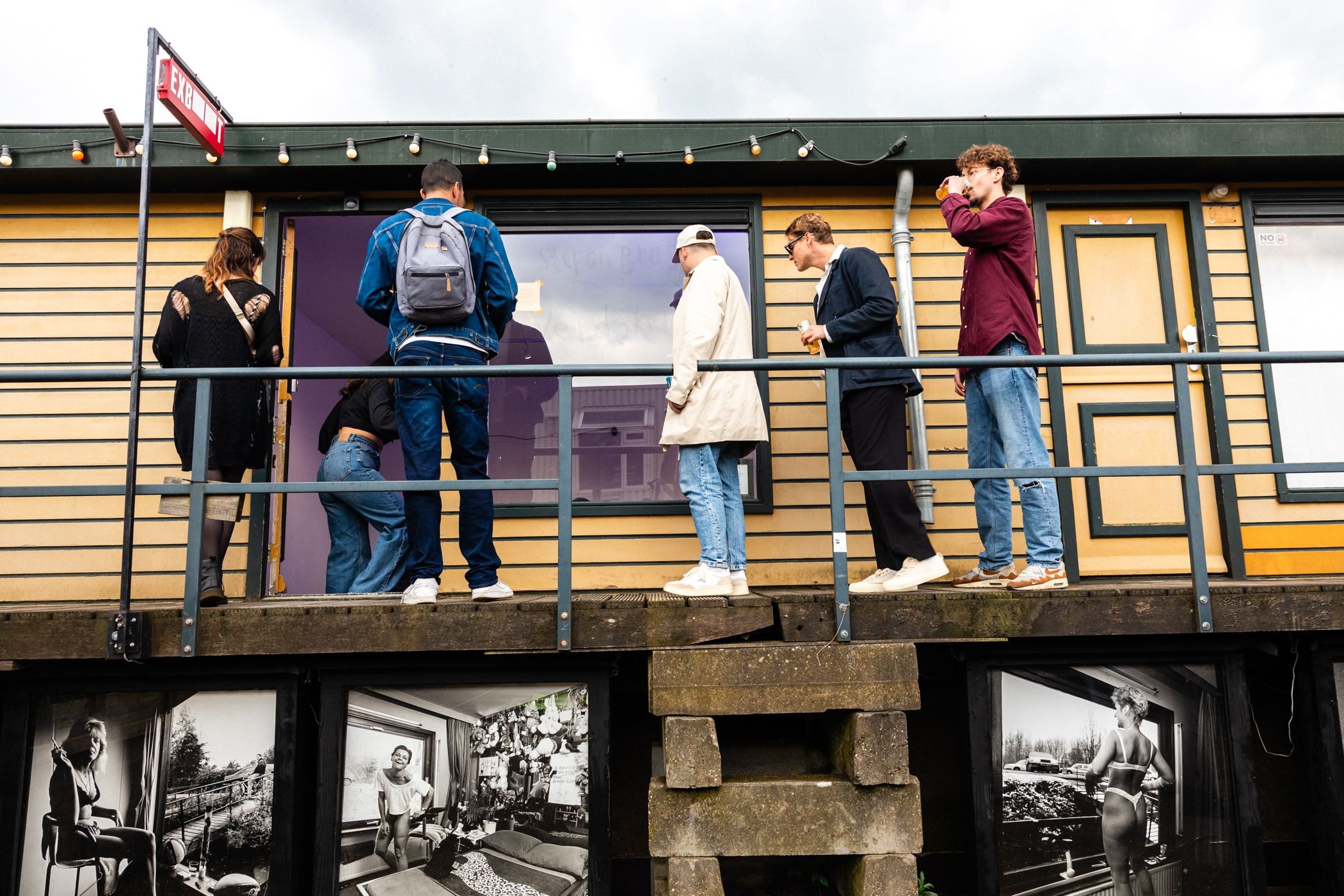 Een groep jonge mannen kijkt door het raam van de EXboot naar binnen