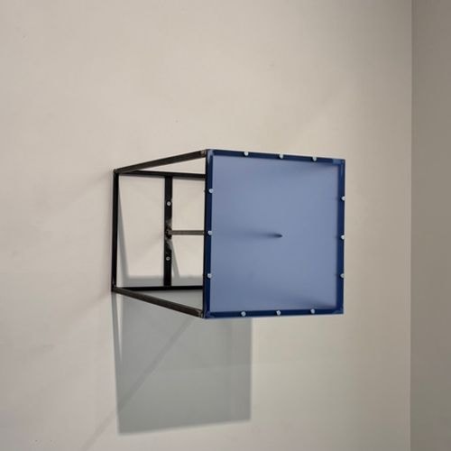 Blauw doorschijnend paneel met donkere kegel in zwart kubusframe, aan een witte muur bevestigd.